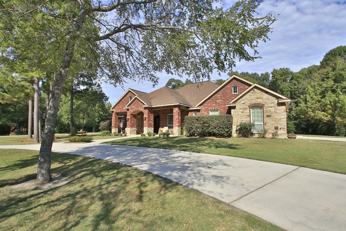1547 Ruby Drive Willis, TX 77378 - Photo 2 of 45 a view of a yard in front of a house with large trees