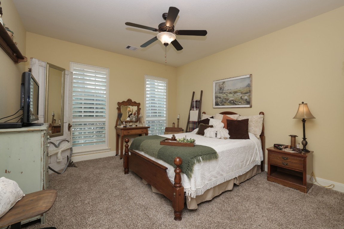 1547 Ruby Drive Willis, TX 77378 - Photo 27 of 45 a spacious bedroom with a bed and a flat tv screen on the dresser