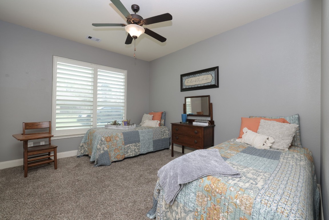1547 Ruby Drive Willis, TX 77378 - Photo 32 of 45 a bedroom with a bed and a chandelier