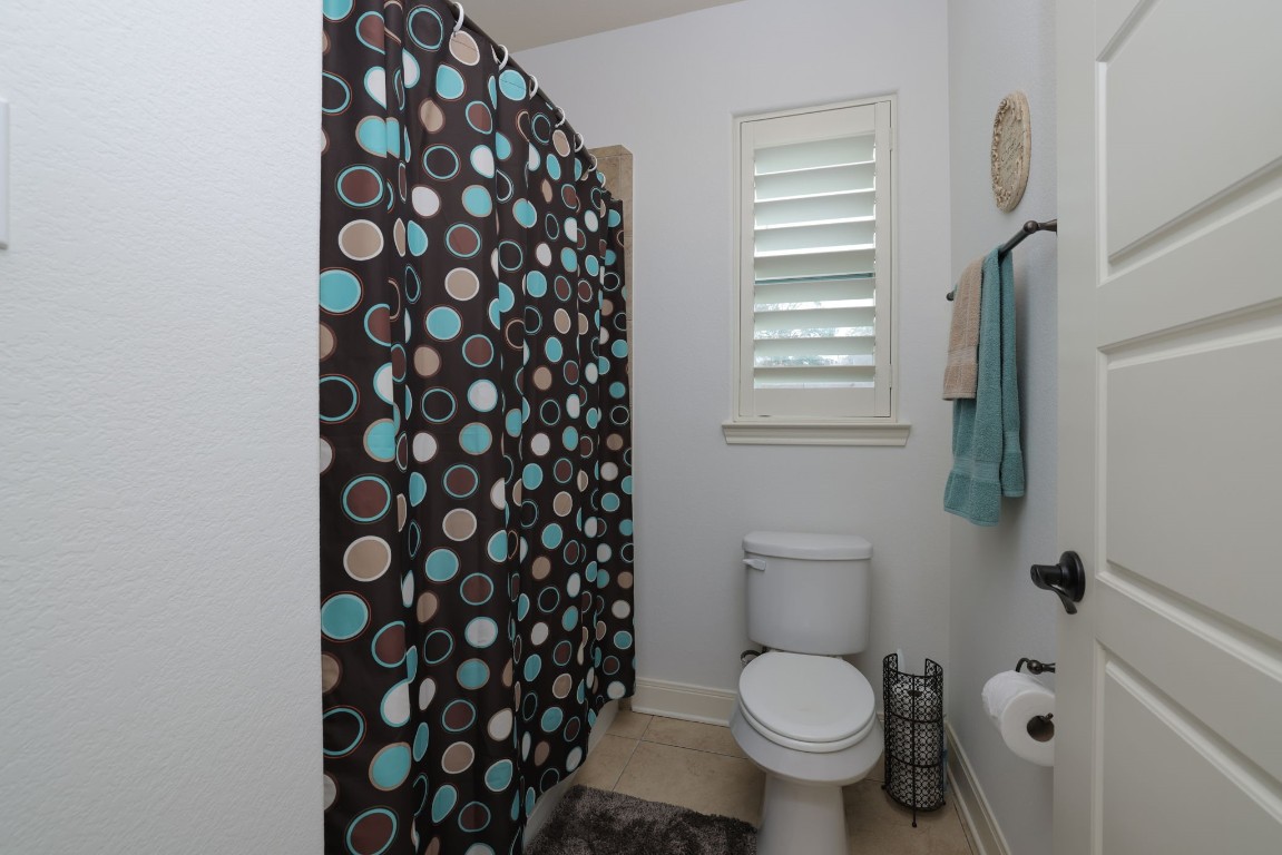 1547 Ruby Drive Willis, TX 77378 - Photo 34 of 45 a a bathroom with a toilet and a shower curtain