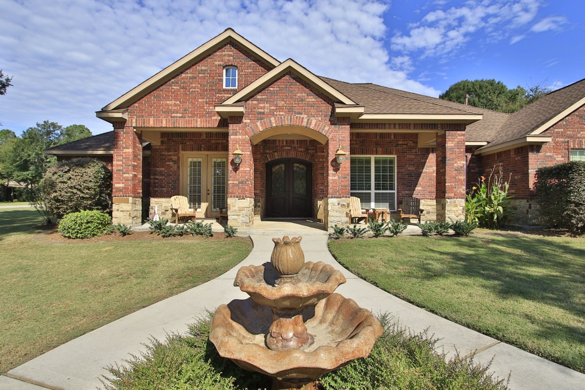 1547 Ruby Drive Willis, TX 77378 - Photo 4 of 45 a front view of a house with a yard fountain