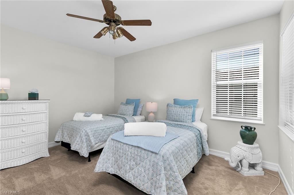 1286 Rialto Way, Unit 9202 Naples, FL 34114 - Photo 21 of 49 Second bedroom with light colored carpet and a ceiling fan.
