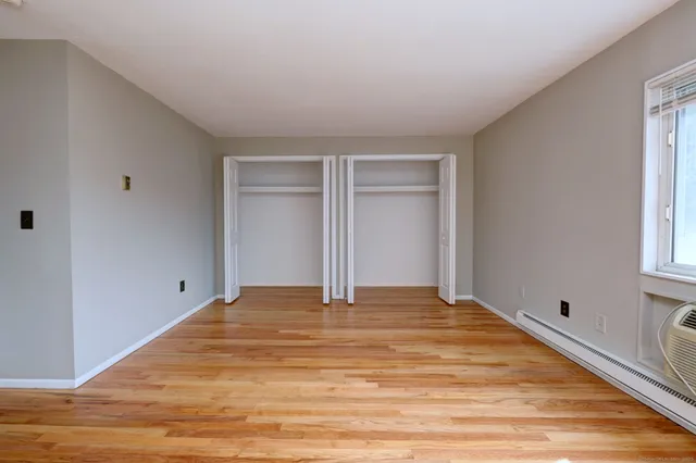 a view of a livingroom with wooden floor and a ceiling fan