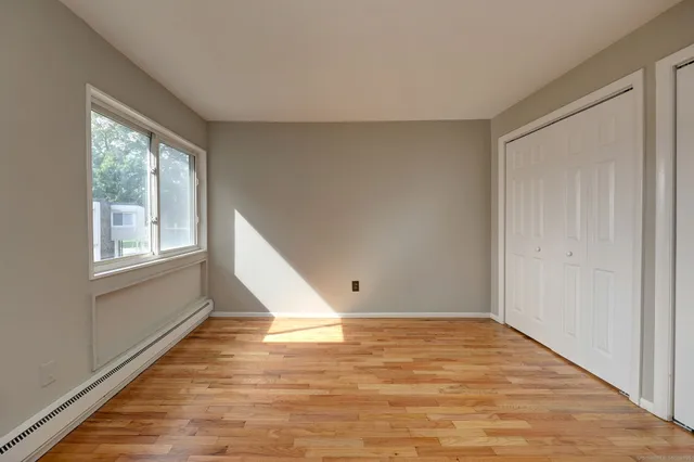 an empty room with wooden floor and closet