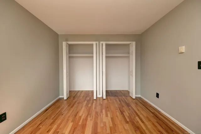 a view of a room with wooden floor and white walls
