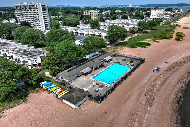 an aerial view of a tennis ground and a cars park side of the road