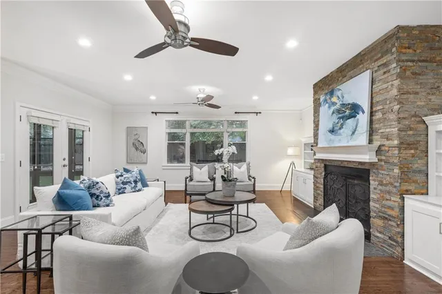 a living room with furniture a fireplace and floor to ceiling windows