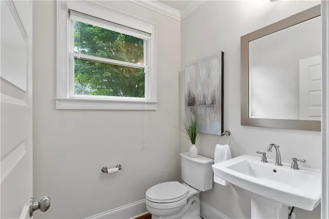 a bathroom with a sink toilet and a mirror