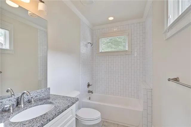 a bathroom with a granite countertop sink toilet a mirror and shower
