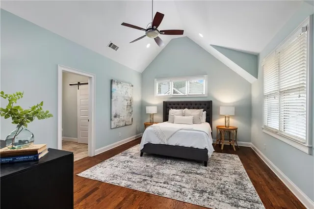a bedroom with a large bed and a potted plant