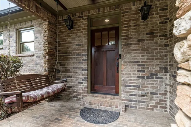 a brick building with a bench and a potted plant