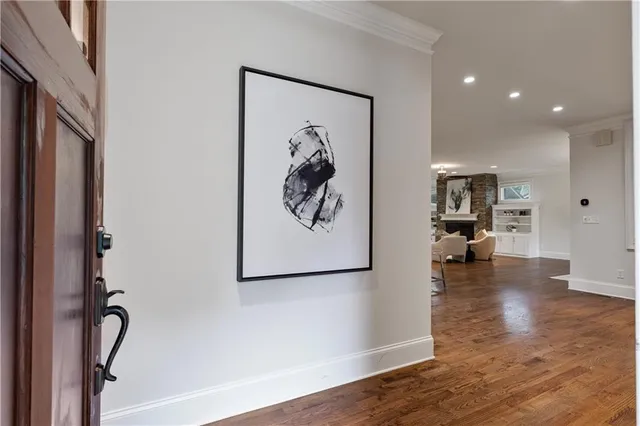 a view of a hallway with wooden floor and a chandelier