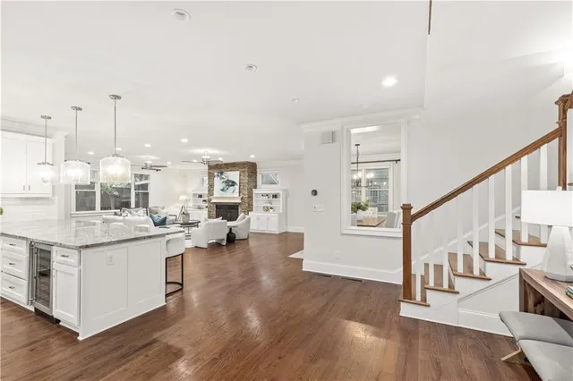 a open kitchen with stainless steel appliances kitchen island wooden floors and living room view
