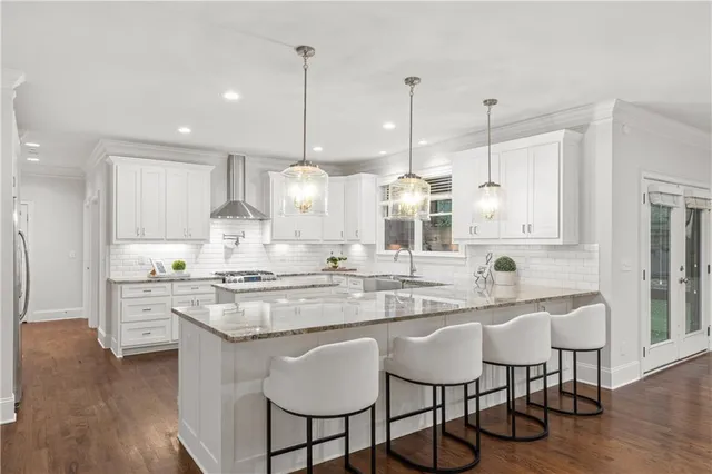 a kitchen with stainless steel appliances granite countertop a stove a sink a island a refrigerator with wooden floor