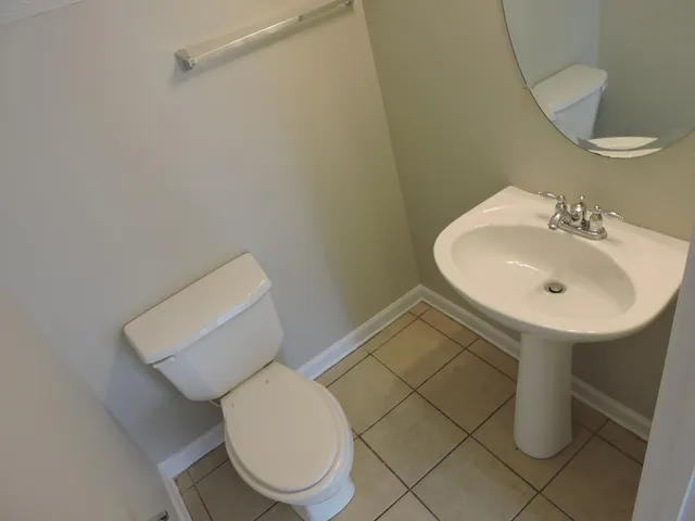 a bathroom with a sink toilet and a mirror