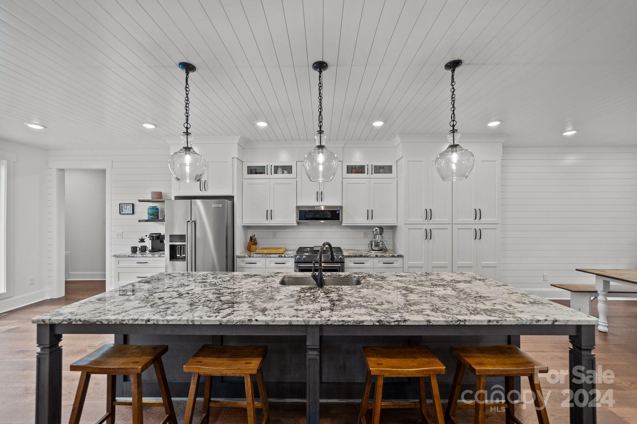450 Bringle Ferry Road Denton, NC 27239 - Photo 21 of 48 a kitchen with kitchen island granite countertop wooden cabinets and a view of living room