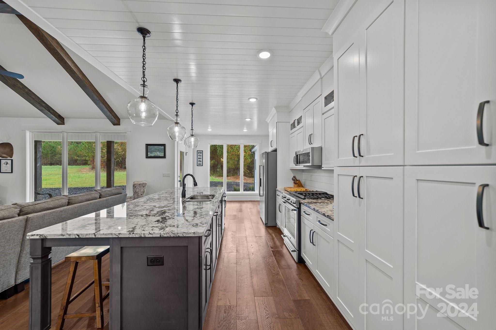 450 Bringle Ferry Road Denton, NC 27239 - Photo 23 of 48 a kitchen with stainless steel appliances granite countertop a sink a stove and a wooden floors
