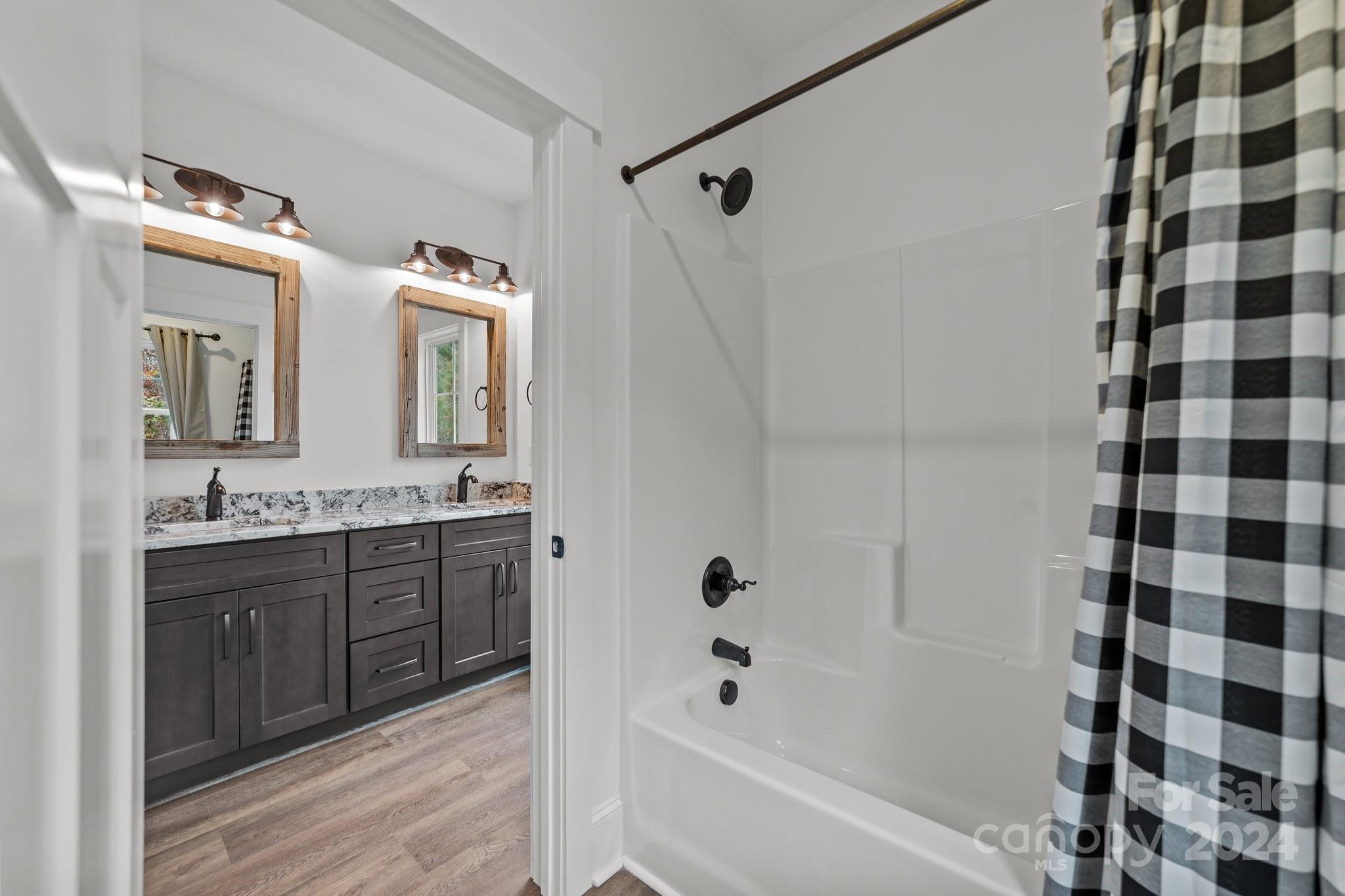 450 Bringle Ferry Road Denton, NC 27239 - Photo 39 of 48 a bathroom with a double vanity sink and mirror with bathtub