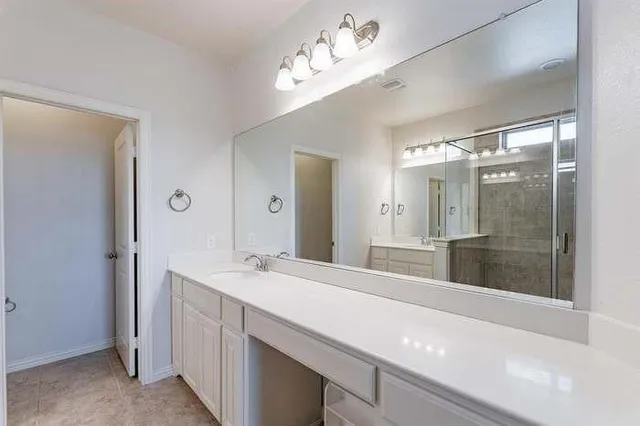 a bathroom with a shower sink vanity and mirror