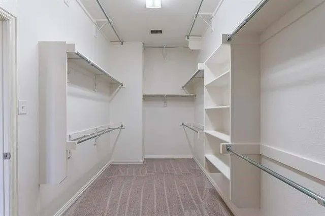 a view of walk in closet with empty racks