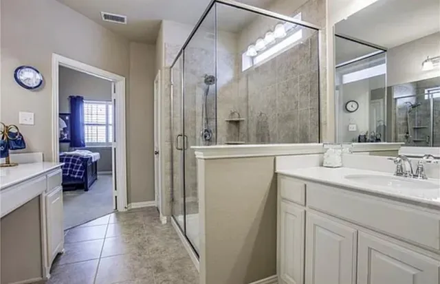 a bathroom with a double vanity sink mirror and shower