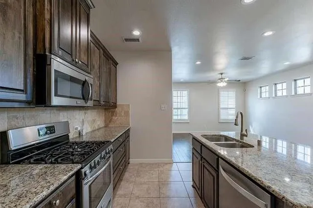 a kitchen with granite countertop stainless steel appliances and sink