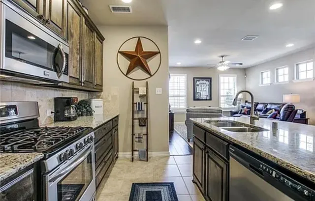 a kitchen with stainless steel appliances granite countertop a stove and a sink