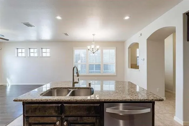a kitchen with stainless steel appliances granite countertop a sink a stove and a refrigerator
