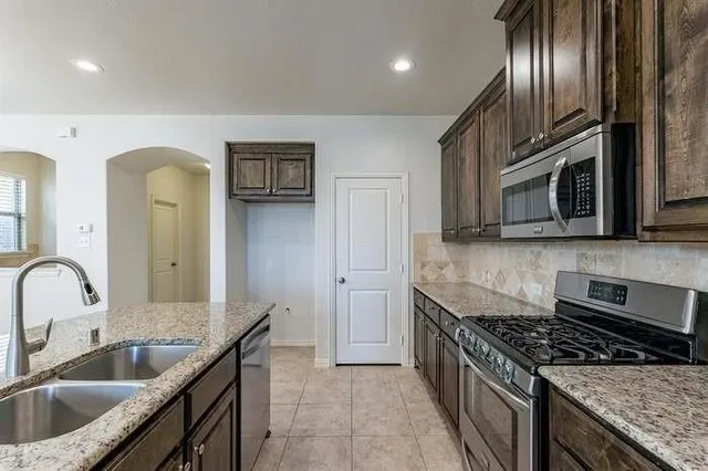 a kitchen with a sink a stove and cabinets
