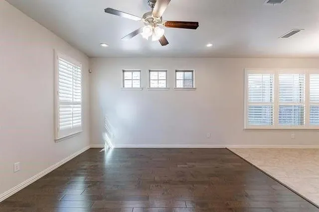 a view of a livingroom with a chandelier fan and windows