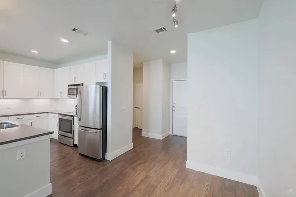 a kitchen with a refrigerator and a stove top oven