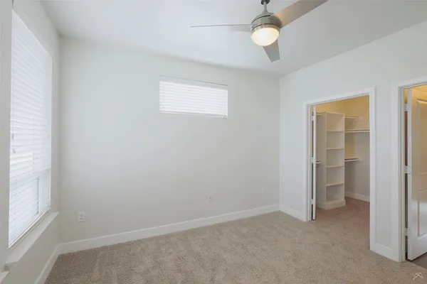 an empty room with closet and windows