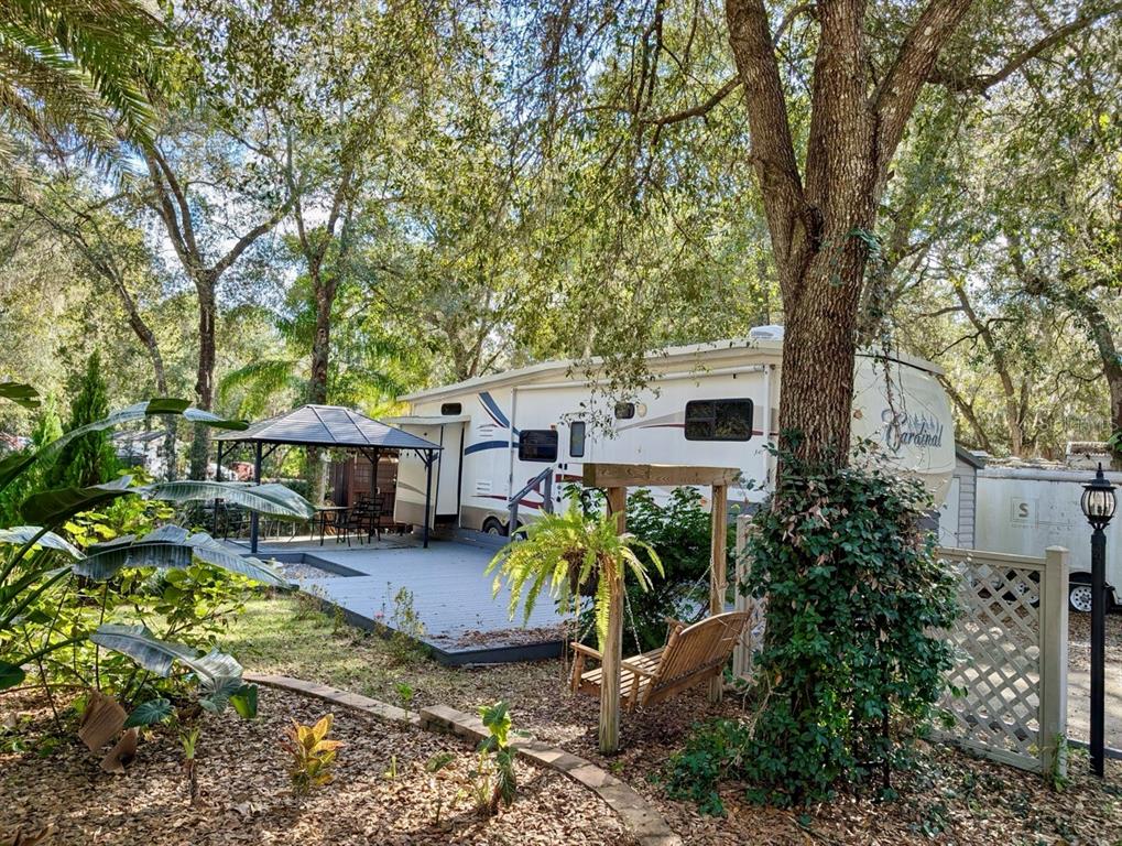 14131 Northeast 253rd Ave Road Salt Springs, FL 32134 - Photo 22 of 26 a view of a house with wooden fence and a large tree