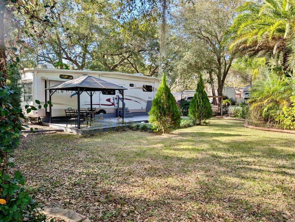 14131 Northeast 253rd Ave Road Salt Springs, FL 32134 - Photo 24 of 26 a view of a house with garden and trees