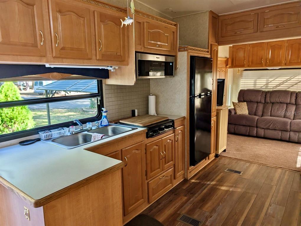 14131 Northeast 253rd Ave Road Salt Springs, FL 32134 - Photo 4 of 26 a kitchen with stainless steel appliances granite countertop a refrigerator a stove and a sink