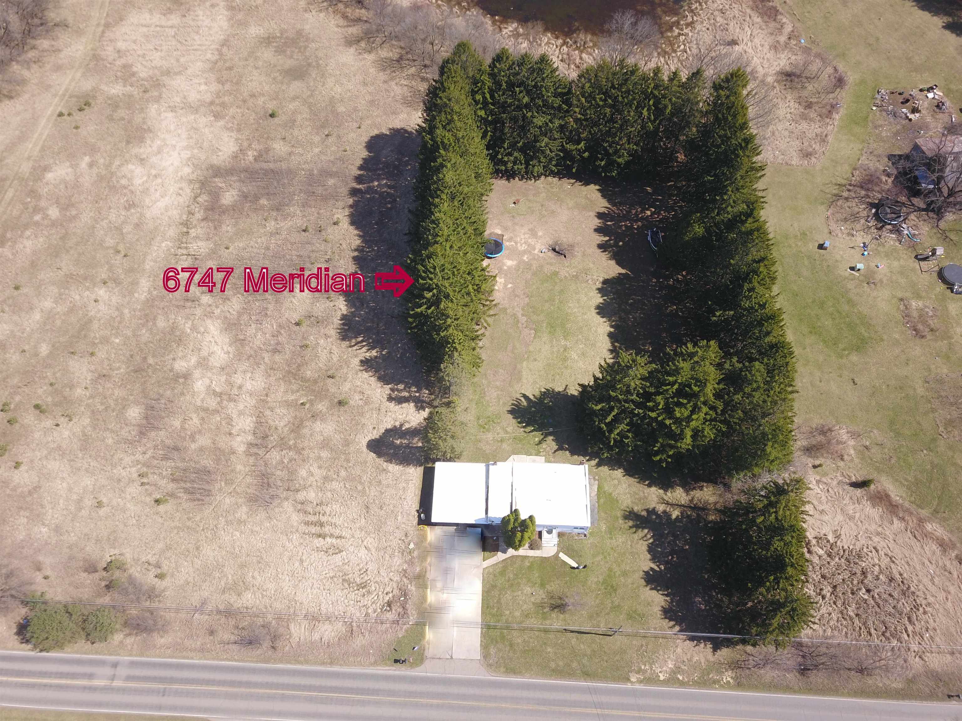 6747 South Meridian Road Laingsburg, MI 48848 - Photo 2 of 18 Almost completely surrounded by trees - private setting. Vehicles removed from driveway in photo.