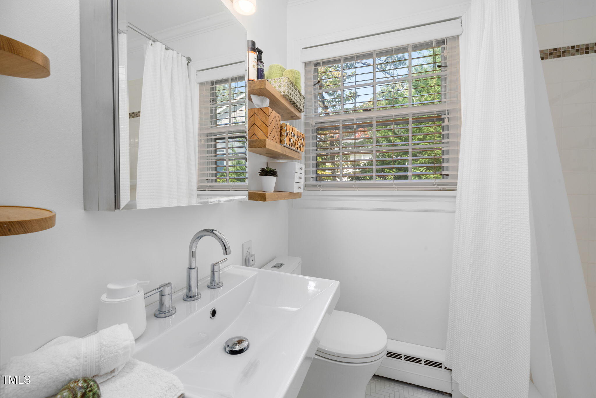 3409 Lewis Farm Road Raleigh, NC 27607 - Photo 17 of 31 a bathroom with a sink a toilet and a window
