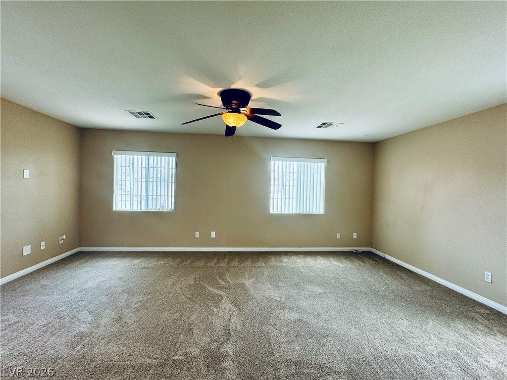 8617 Palomino Ranch Street Las Vegas, NV 89131 - Photo 13 of 27 A spacious room offers ample natural light and a practical ceiling fan for year-round comfort.