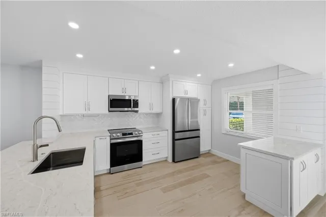 a kitchen with stainless steel appliances granite countertop a refrigerator and a sink