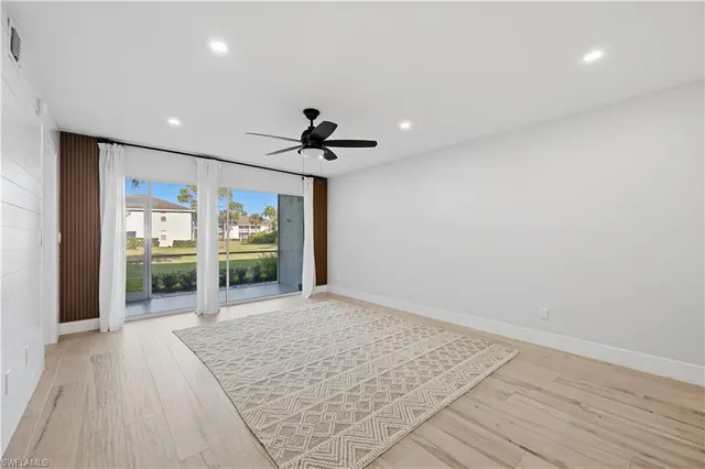 a view of hallway with wooden floor and livingroom with couch