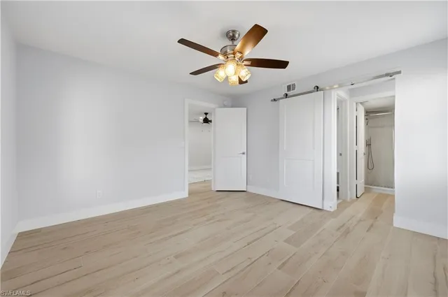 a view of an empty room with wooden floor
