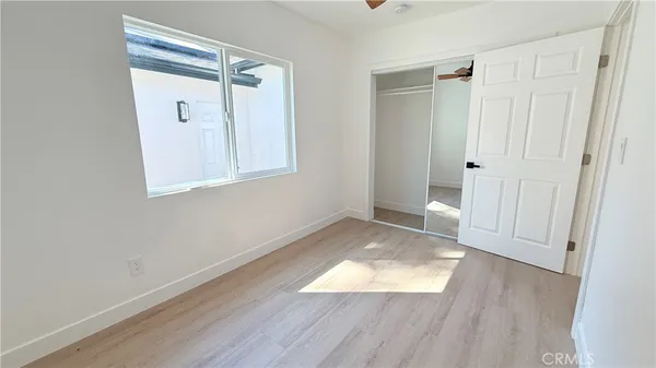 an empty room with wooden floor and entrance