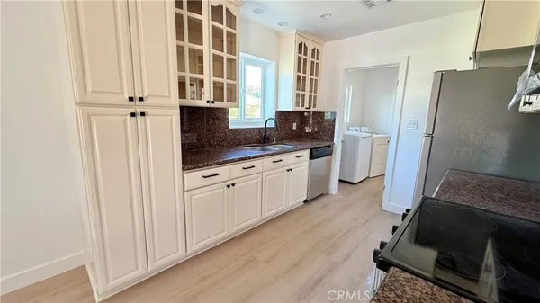 a kitchen with stainless steel appliances a refrigerator sink and cabinets