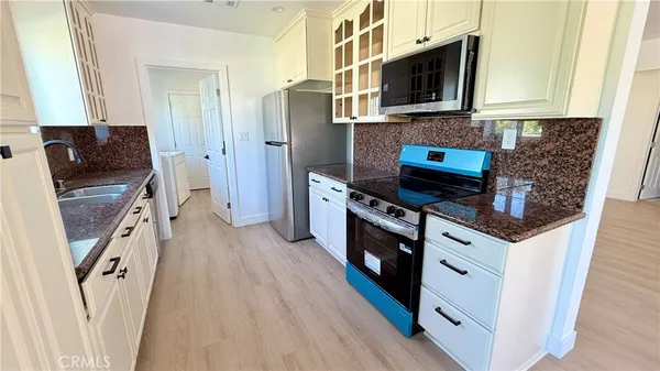 a kitchen with stainless steel appliances a stove microwave and a sink
