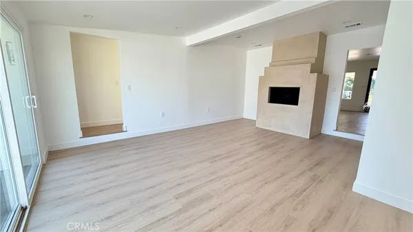an empty room with wooden floor and entrance