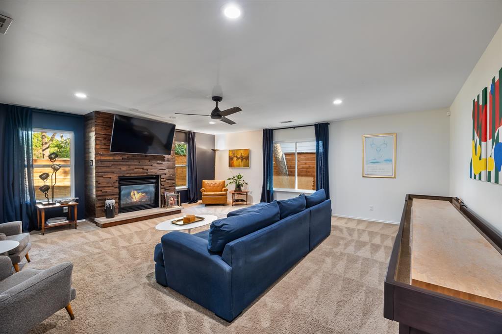 11718 Rogue Way Dallas, TX 75218 - Photo 15 of 35 a living room with furniture a fireplace a flat screen tv and a large window