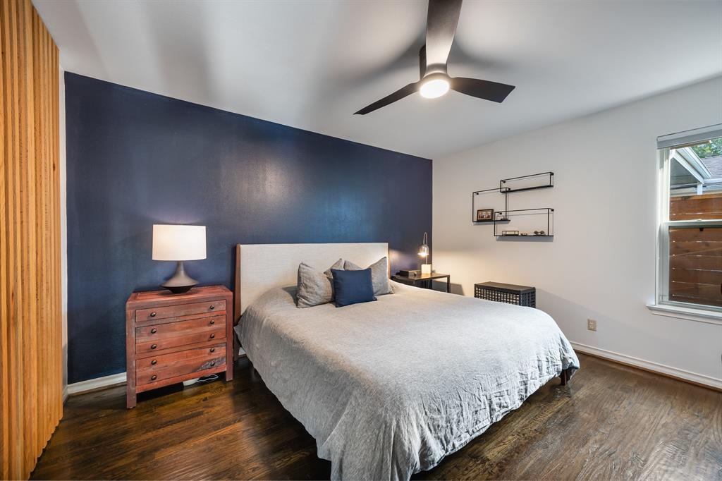 11718 Rogue Way Dallas, TX 75218 - Photo 18 of 35 a bedroom with a bed and wooden floor