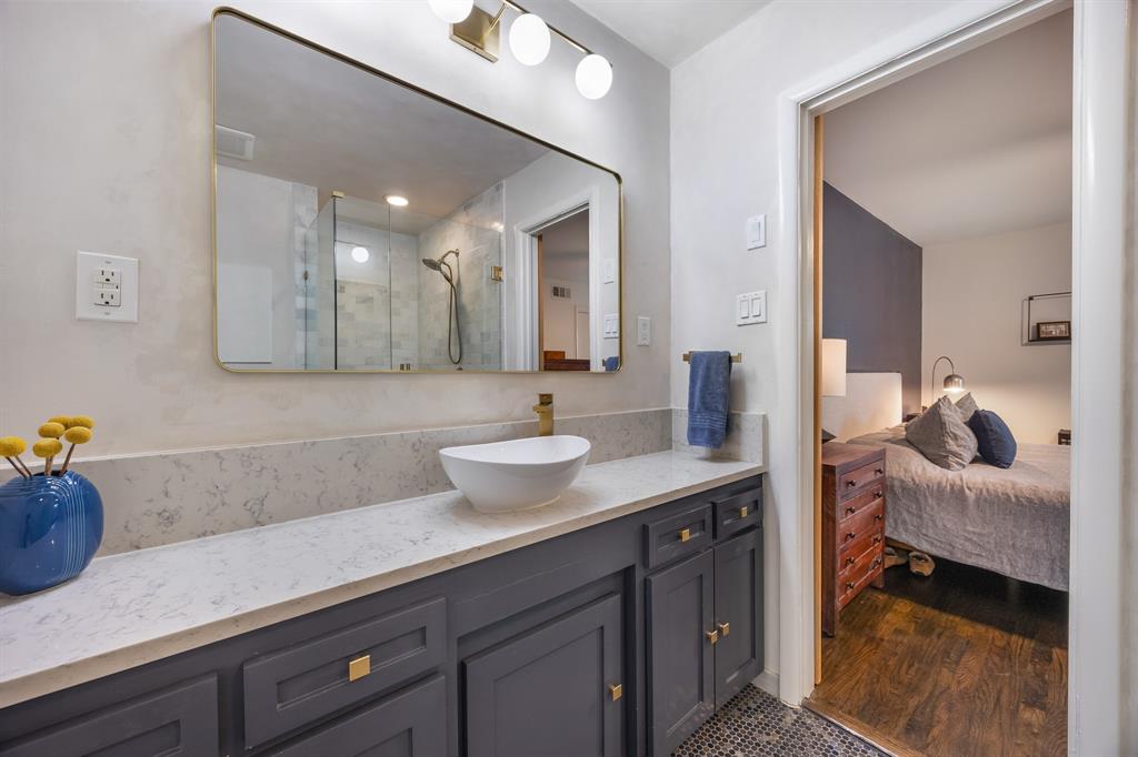 11718 Rogue Way Dallas, TX 75218 - Photo 20 of 35 a en suite bathroom with a granite countertop sink and a mirror