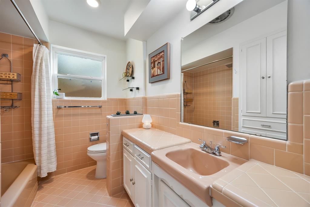 11718 Rogue Way Dallas, TX 75218 - Photo 22 of 35 a bathroom with a granite countertop sink toilet mirror vanity and shower