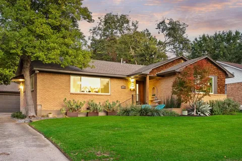 a view of a backyard with barn plants and large tree